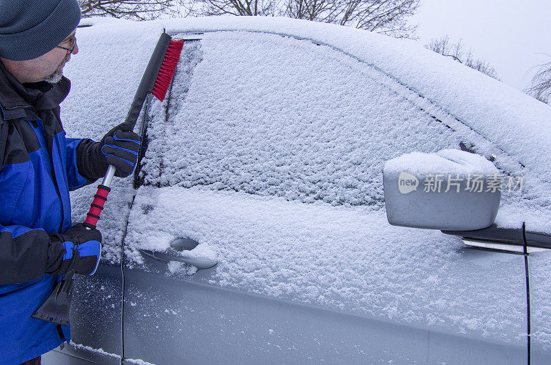 一名男子在刷车上的雪