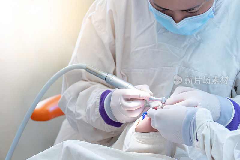 女亚洲牙医在牙科诊所使用仪器治疗和钻孔病人的牙齿。牙科程序和医疗。