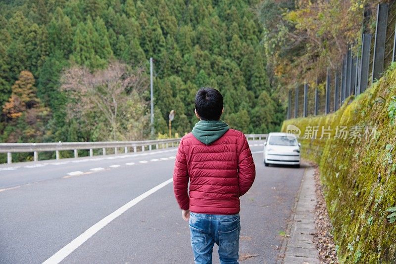 一名公路旅行者向他的车走去