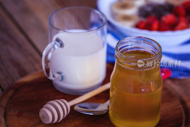 蜂蜜在罐子和牛奶在玻璃，特写