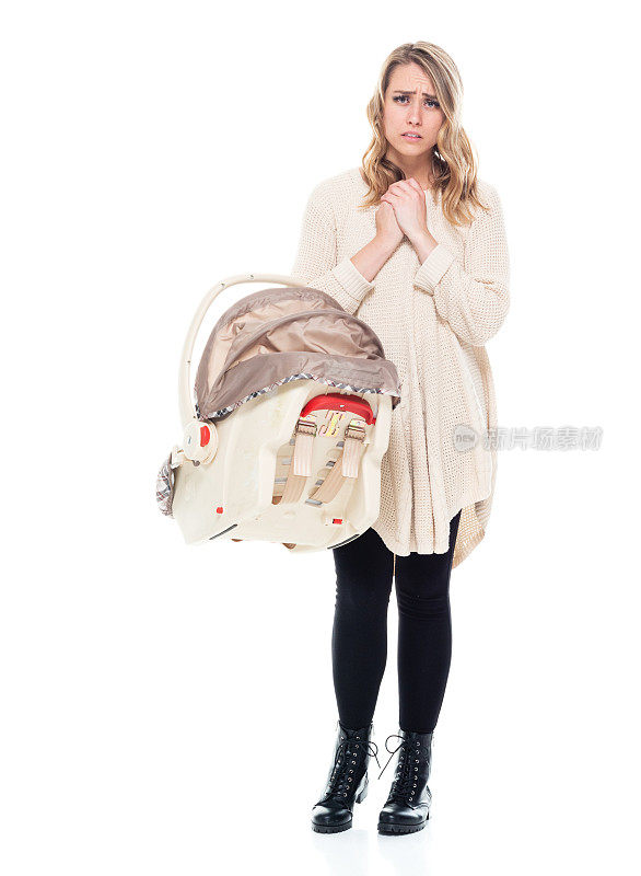 单身母亲穿着毛衣与婴儿汽车座椅恳求