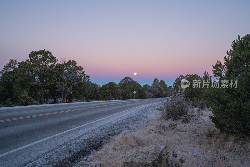 美国亚利桑那州，黎明时分，满月下粉红天空的大峡谷景色令人惊叹