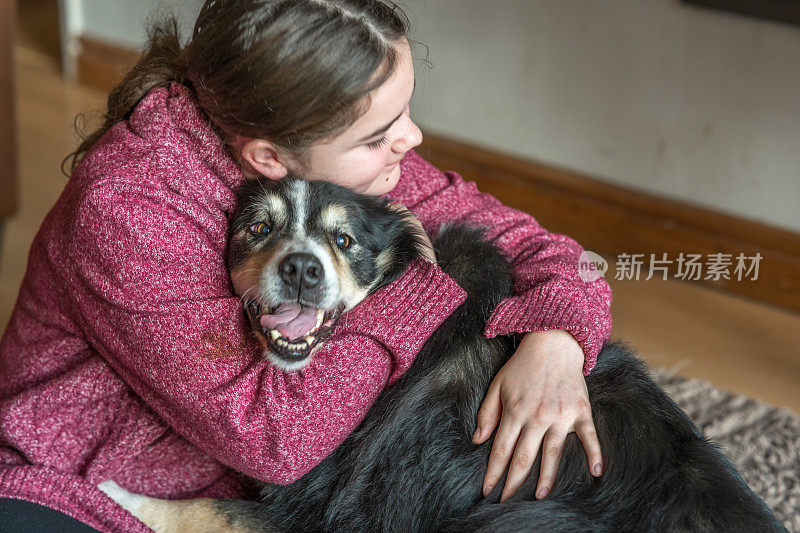 十几岁的女孩拥抱宠物边境牧羊犬