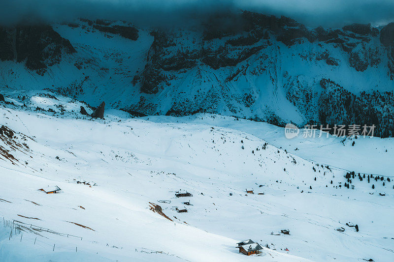 在意大利Dolomites，在蓝色的时间里，可以看到被雪覆盖的山和山上的小屋