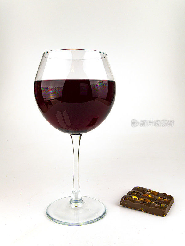 白色背景上的红酒和巧克力。