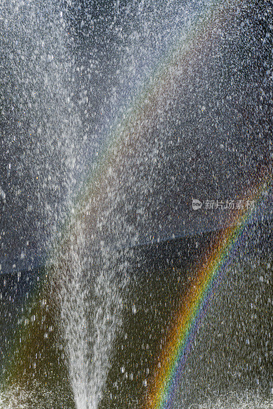 彩虹在喷水池溅起的水里