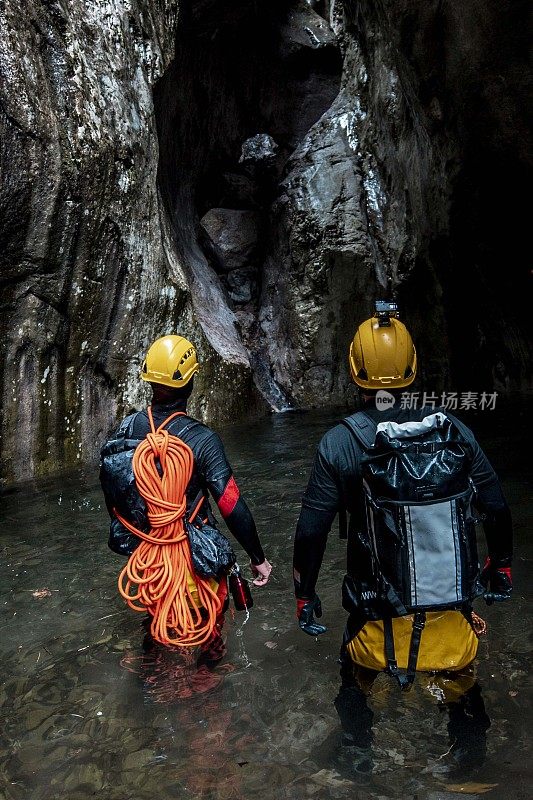 两个攀峡者通过峡谷底部的一条狭窄地带