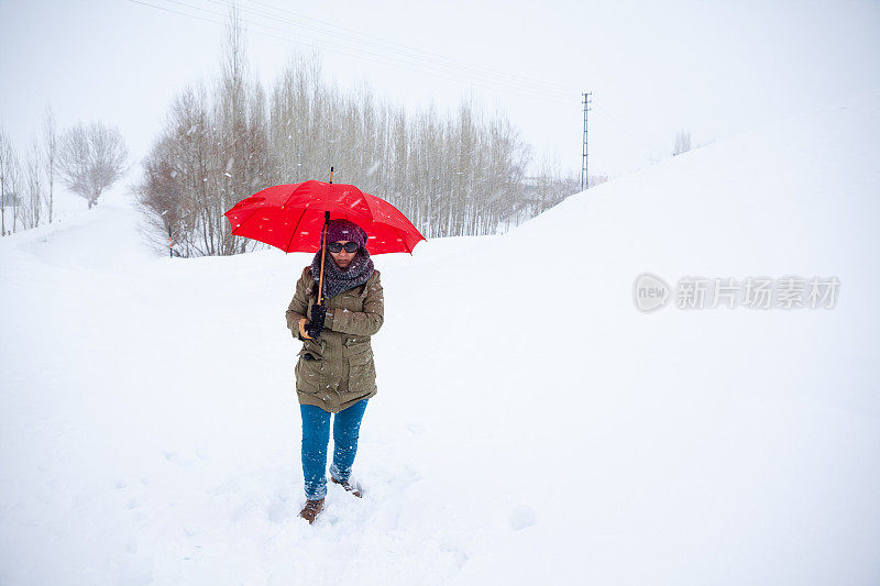 在雪中穿着暖和的衣服和贝雷帽的成年妇女肖像