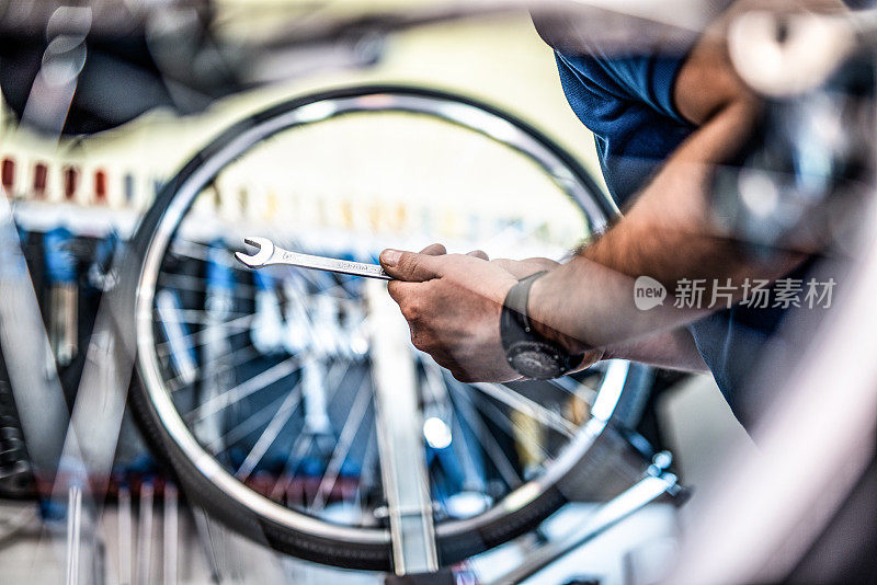 自行车修理工拿着扳手正在修理一个轮子