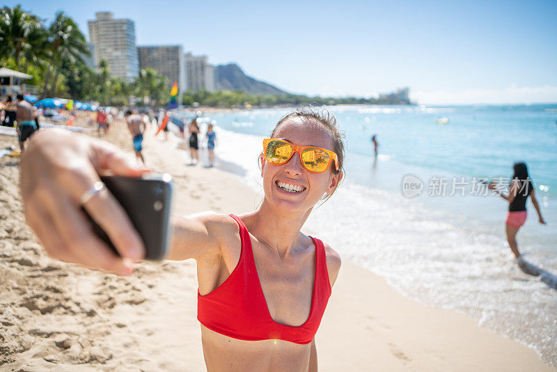 年轻女子在檀香山美丽的海滩自拍照片，夏威夷，美国