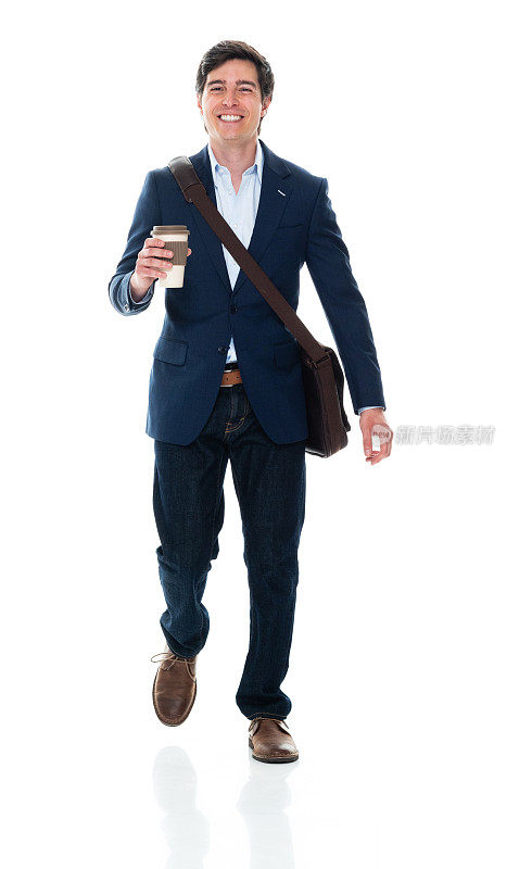 白种年轻男性商人背着小提包，拿着咖啡杯走在白色背景前