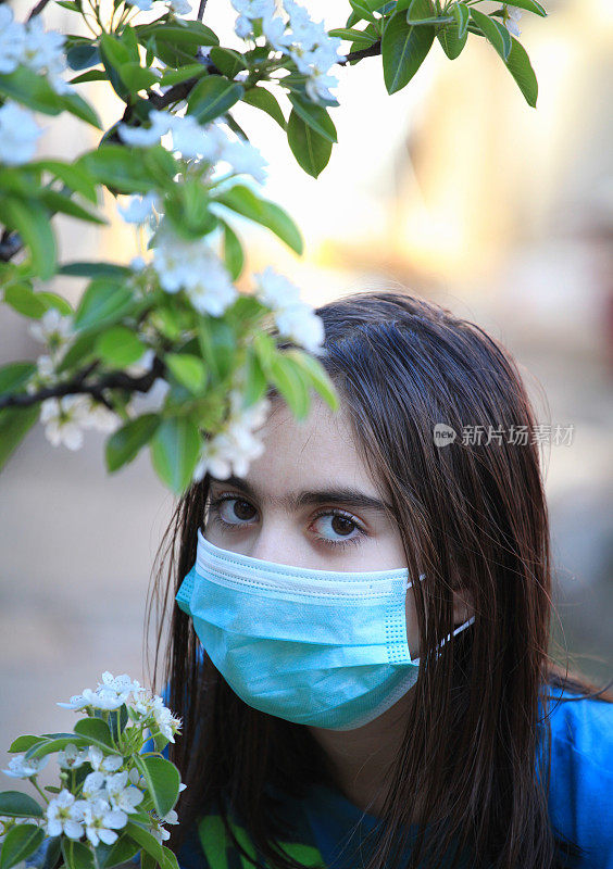 戴面具的女孩正在欣赏花朵