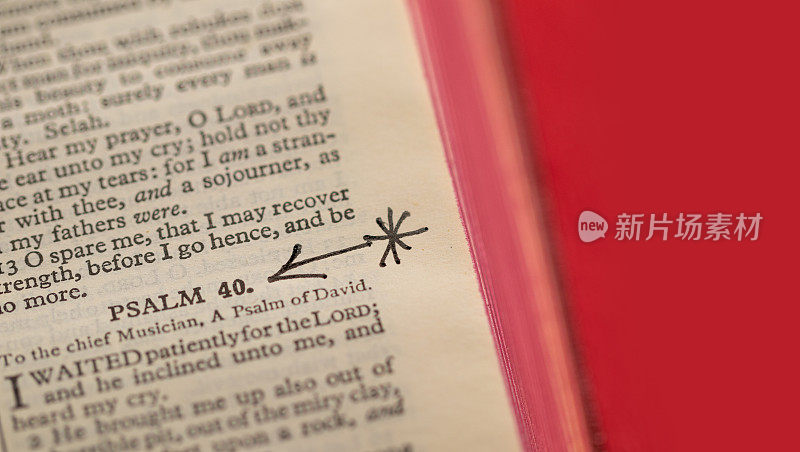 近距离微距图像的一页从圣经显示诗篇40高亮与一个箭头。易于扩展红色背景