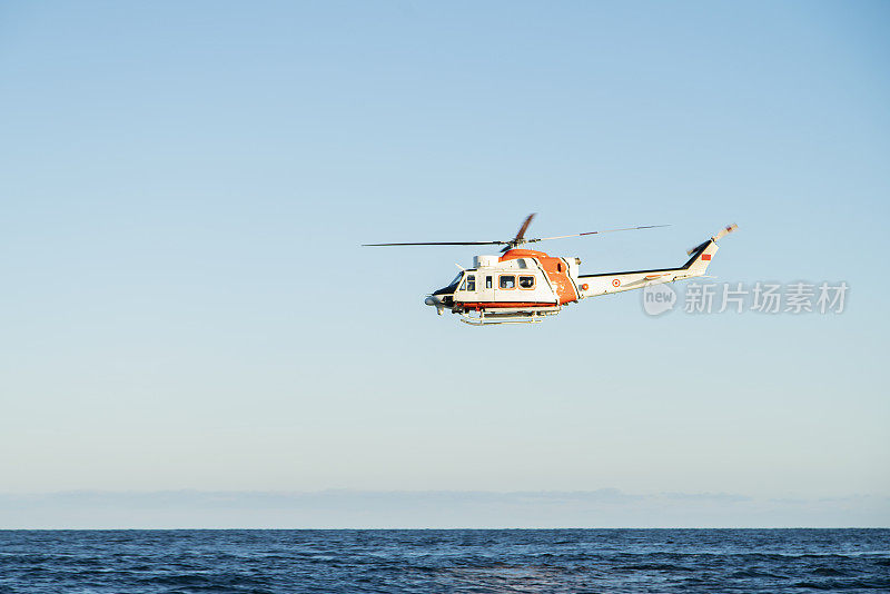 海岸警卫队直升机在晴朗的蓝天下飞行