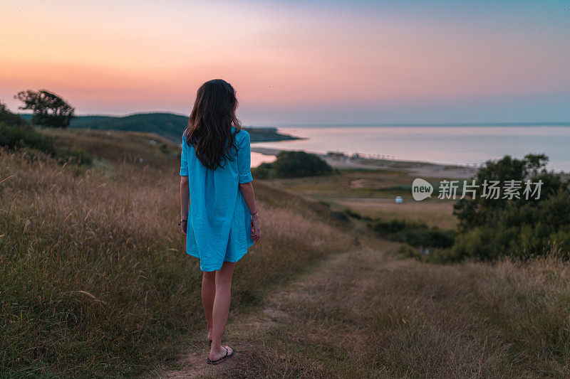 夏日冒险的女人在海滩日落在黄金时间。户外的乐趣和友谊。