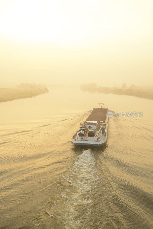 在一个美丽的秋天的早晨，船在IJssel河上的日出