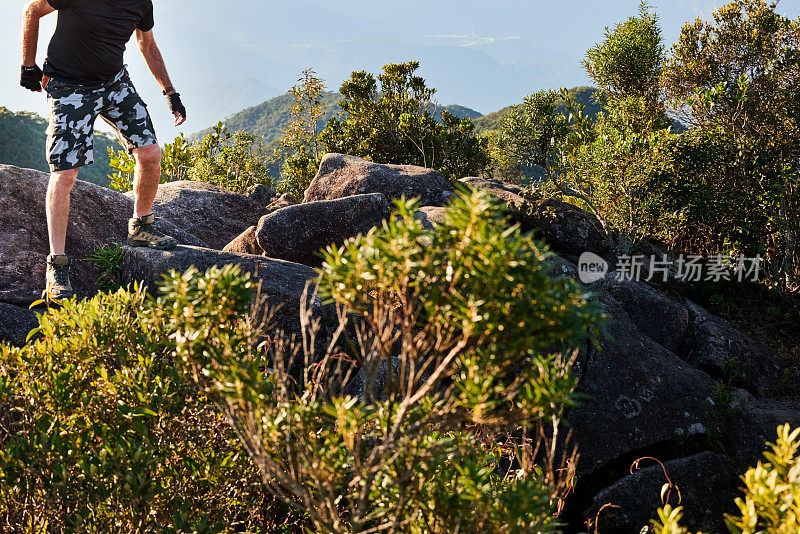 他小心翼翼地从岩石上爬下来