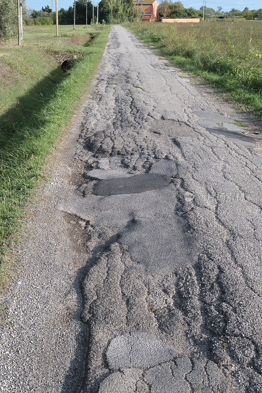 有损坏的柏油碎石的乡村公路