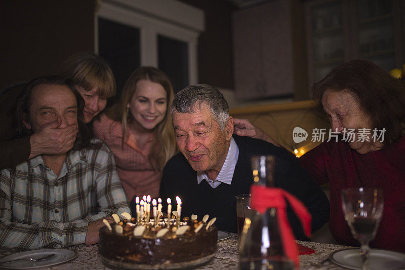 爷爷吹蜡烛庆祝他的八十大寿