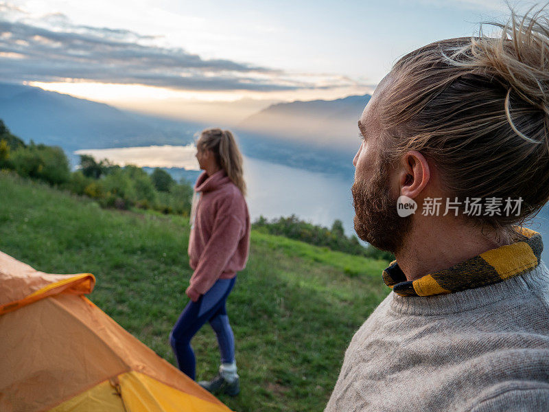 一对夫妇在山顶露营，日出