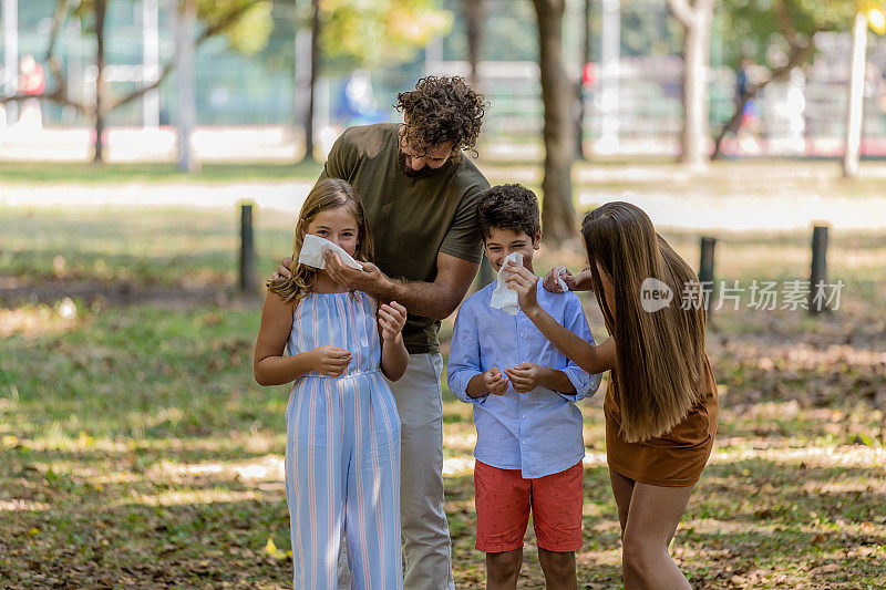 季节性过敏的生病家庭用纸巾擤鼻涕。