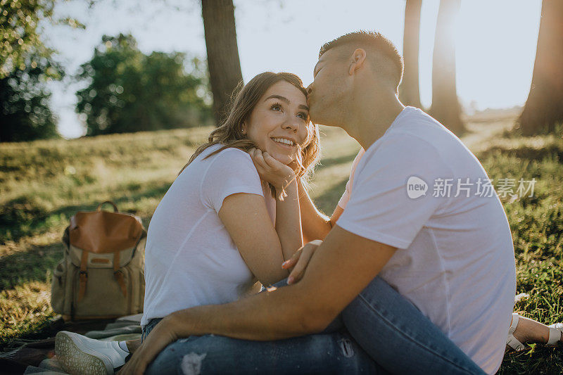 可爱的夫妇在草地上欣赏日落