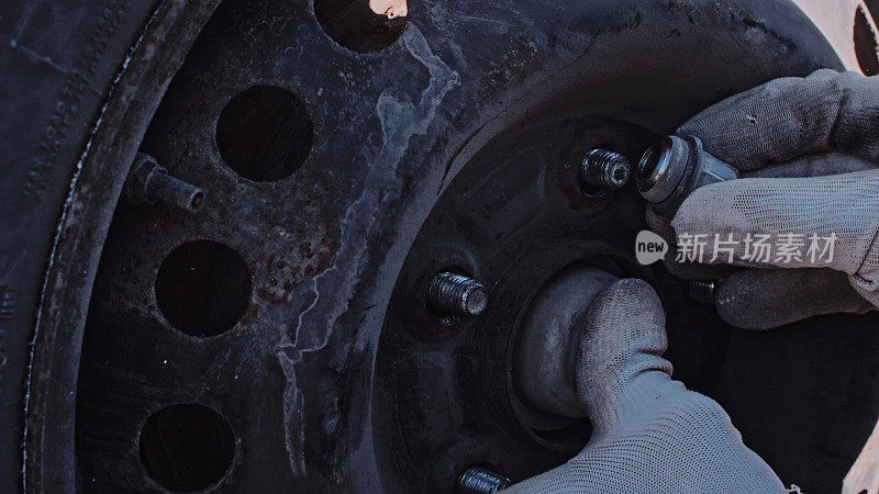 一位妇女在乡村公路上给汽车换轮胎。DIY