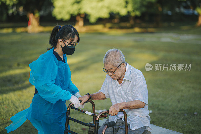 亚洲医疗保险中国女性理疗师纠正姿势，帮助老年男子在公园行走与移动步行者