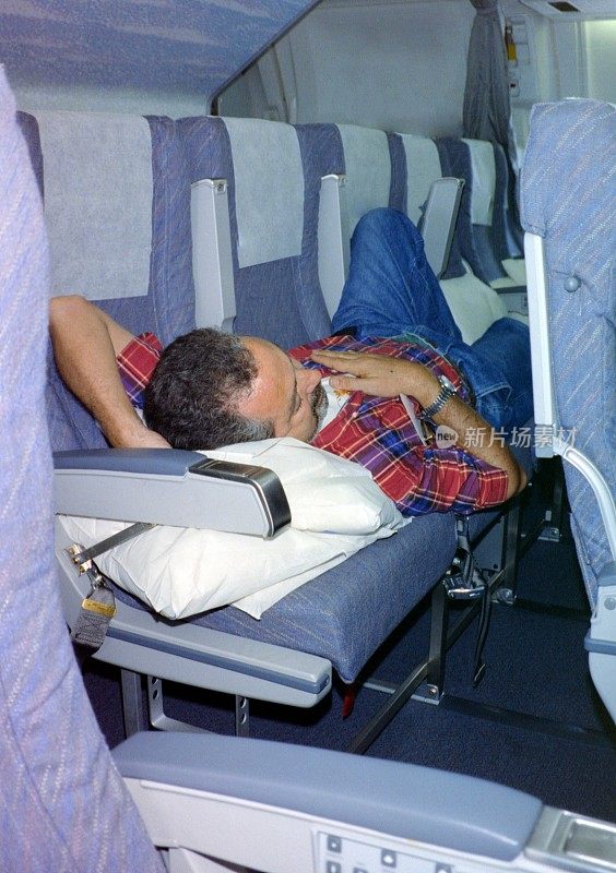 年代。1991年，一名疲惫的游客在飞往印尼巴厘岛度假的飞机上。