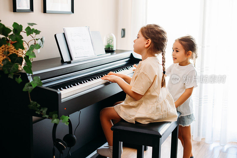 两姐妹在一起练习钢琴