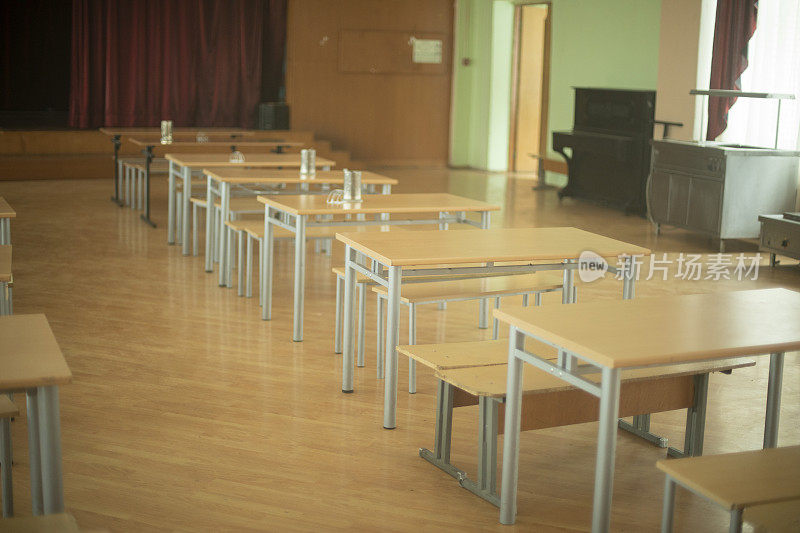 俄罗斯学校食堂。桌子在大厅里排成一排。公共餐饮场所。在学校的礼堂。