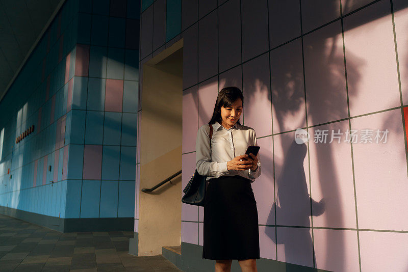 亚洲女性在城市背景下使用手机