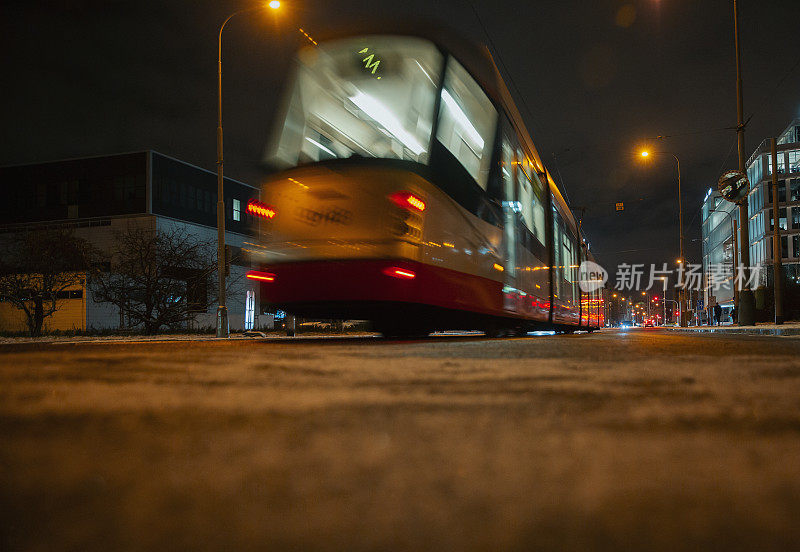 灯火通明的公共汽车在夜晚的城市街道上疾驰