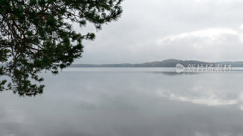 雾蒙蒙的风景，阴雨绵绵的，灰蒙蒙的秋景来自湖水，灰色的天空，平静的水面