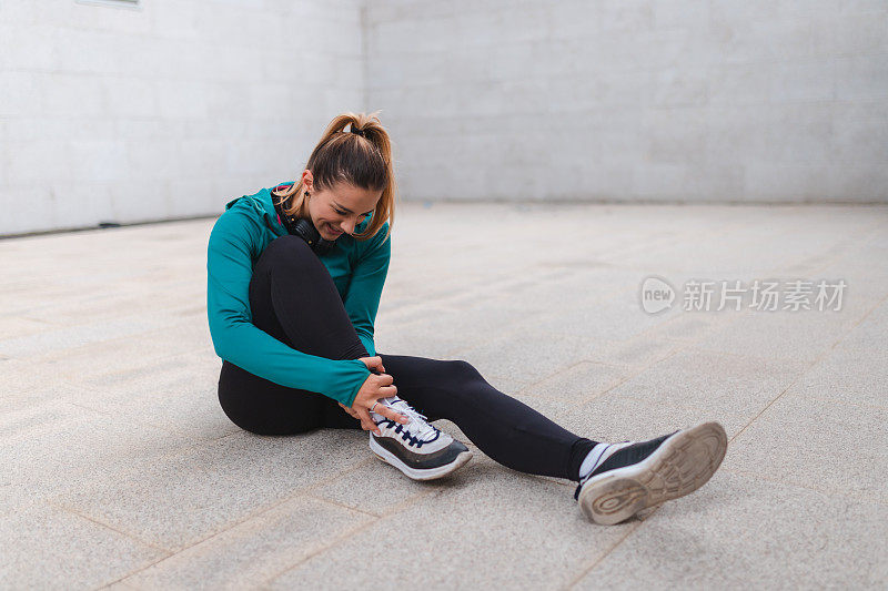 年轻的女运动员在户外锻炼时扭伤了脚踝