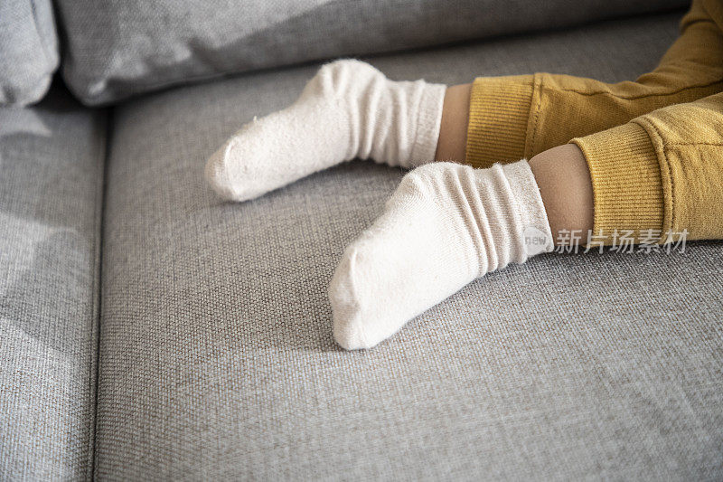 孩子的脚睡在沙发上。白天打盹，靠近点。