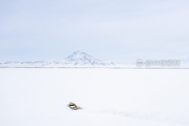 渔船停在白雪覆盖的湖面上