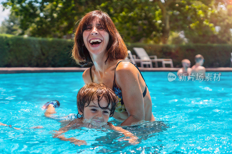 妈妈和儿子在游泳池放暑假，和妈妈一起学游泳