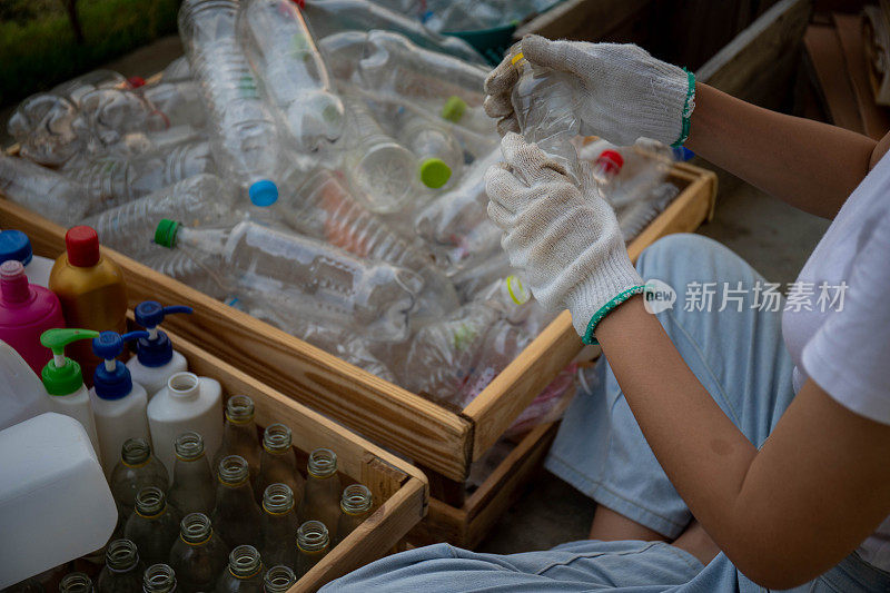 废物处理工人用工作手套拿着塑料瓶