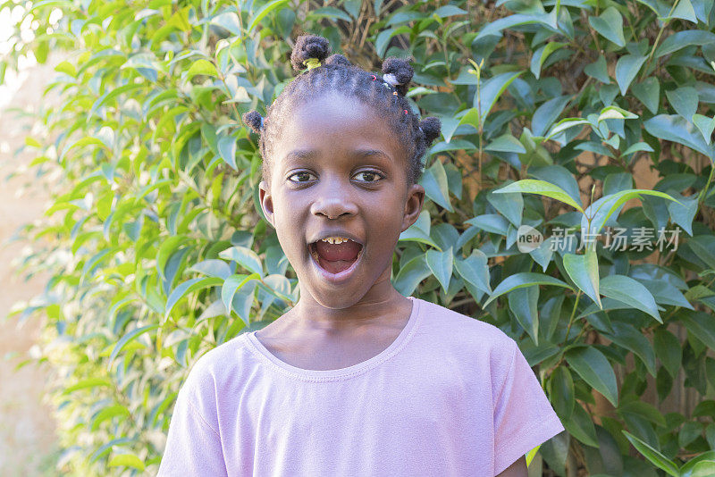 快乐的美国黑人小女孩在户外花园尖叫的肖像