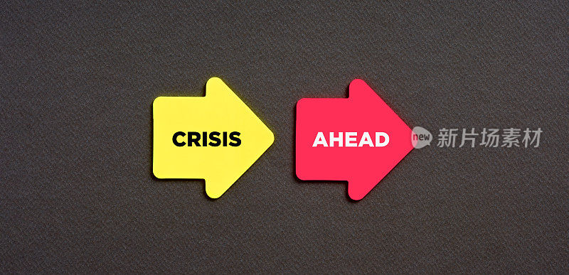 走向经济金融的商业危机之路。“危机”一词出现在蓝色背景的箭头形贴纸上。