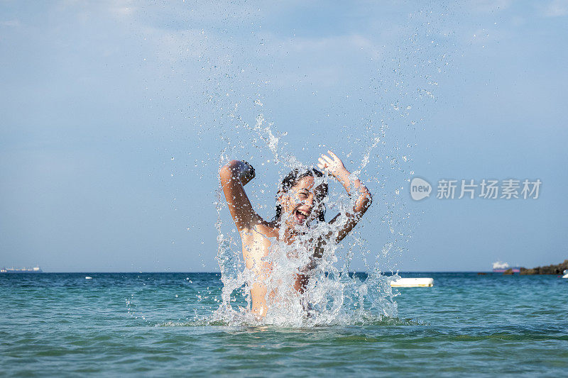 他用手在海里泼水。一个夏天的早晨。忒涅多斯岛。爱琴海北部，12岁的帅哥。长头发的