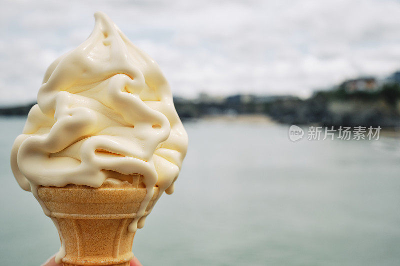 6月的一天，英国康沃尔郡纽基海岸，香草软冰淇淋甜筒的镜头。