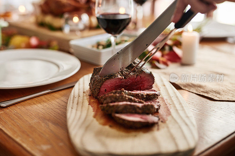 圣诞节餐桌上的手、肉、肉、肉等可用于节日盛宴、庆祝食品或美酒。牛肉，切片或刀度假餐或假日牛排午餐或社交聚会，晚餐在事件