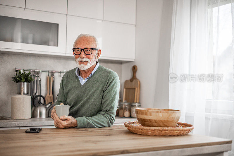 老人，领养老金的人，坐在厨房里开心地笑着，喝着热咖啡或茶，早晨的例行程序，无忧无虑的退休日子