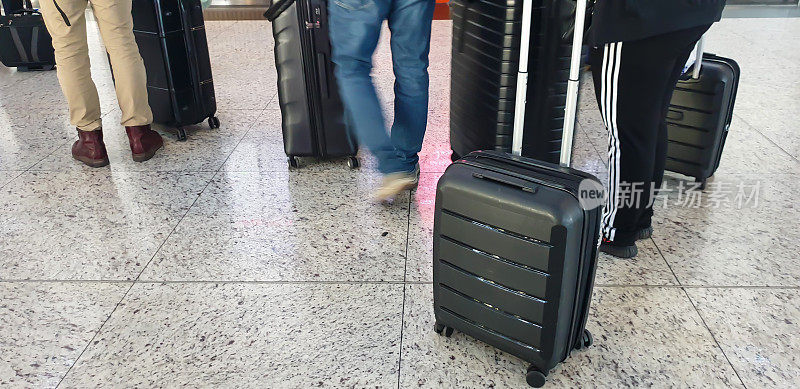 带着行李在机场排队等候的乘客