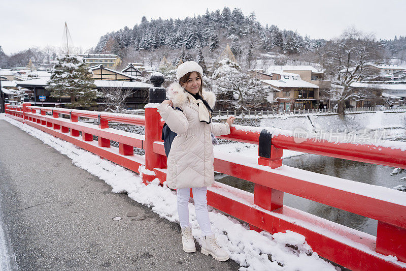 美丽的女游客享受他们的日本之旅在雪的冬天