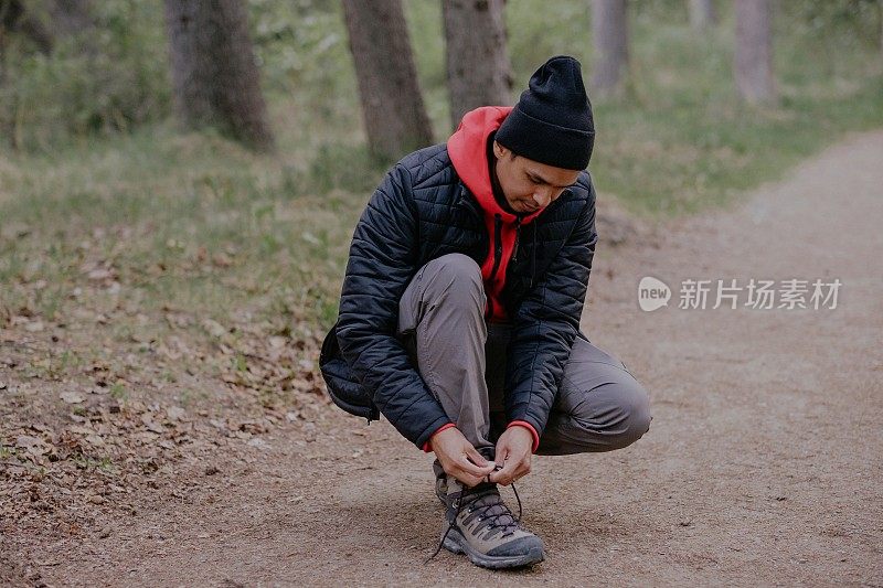 男人在森林里系鞋带