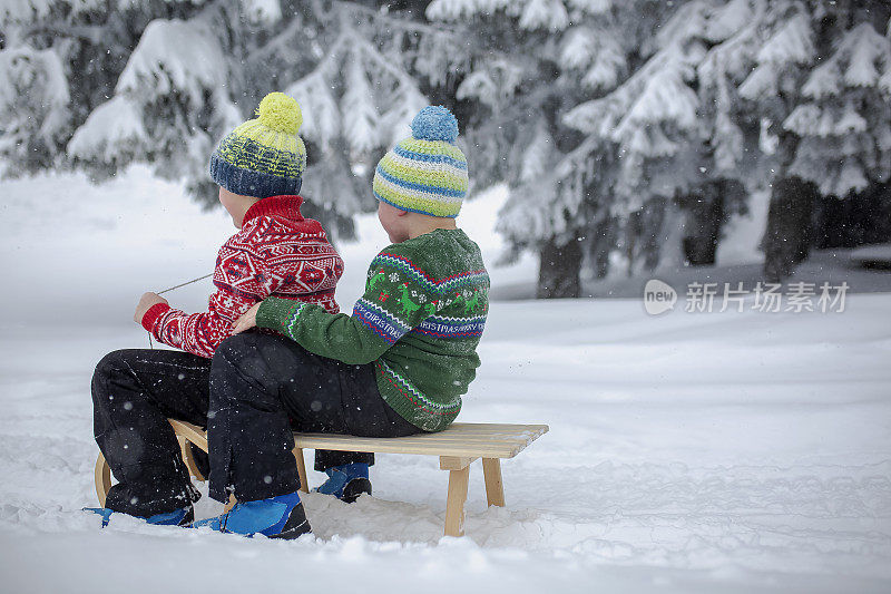 小男孩在雪地上拉雪橇