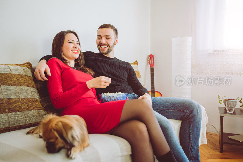 年轻夫妇在家里看电视